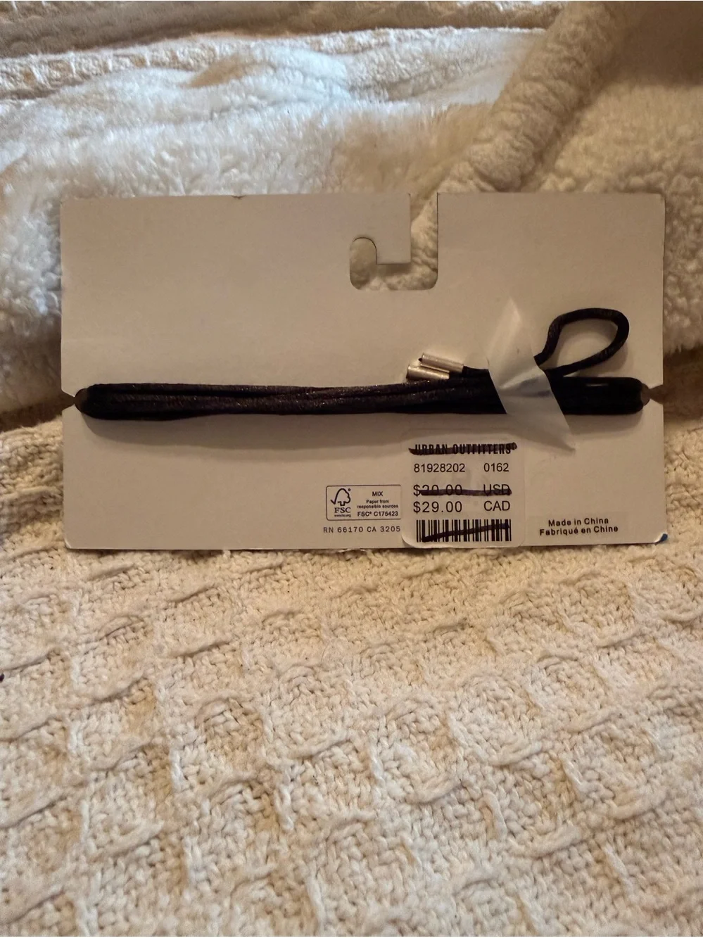 Urban Outfitters silver metal rose flower hair tie on a black cord.